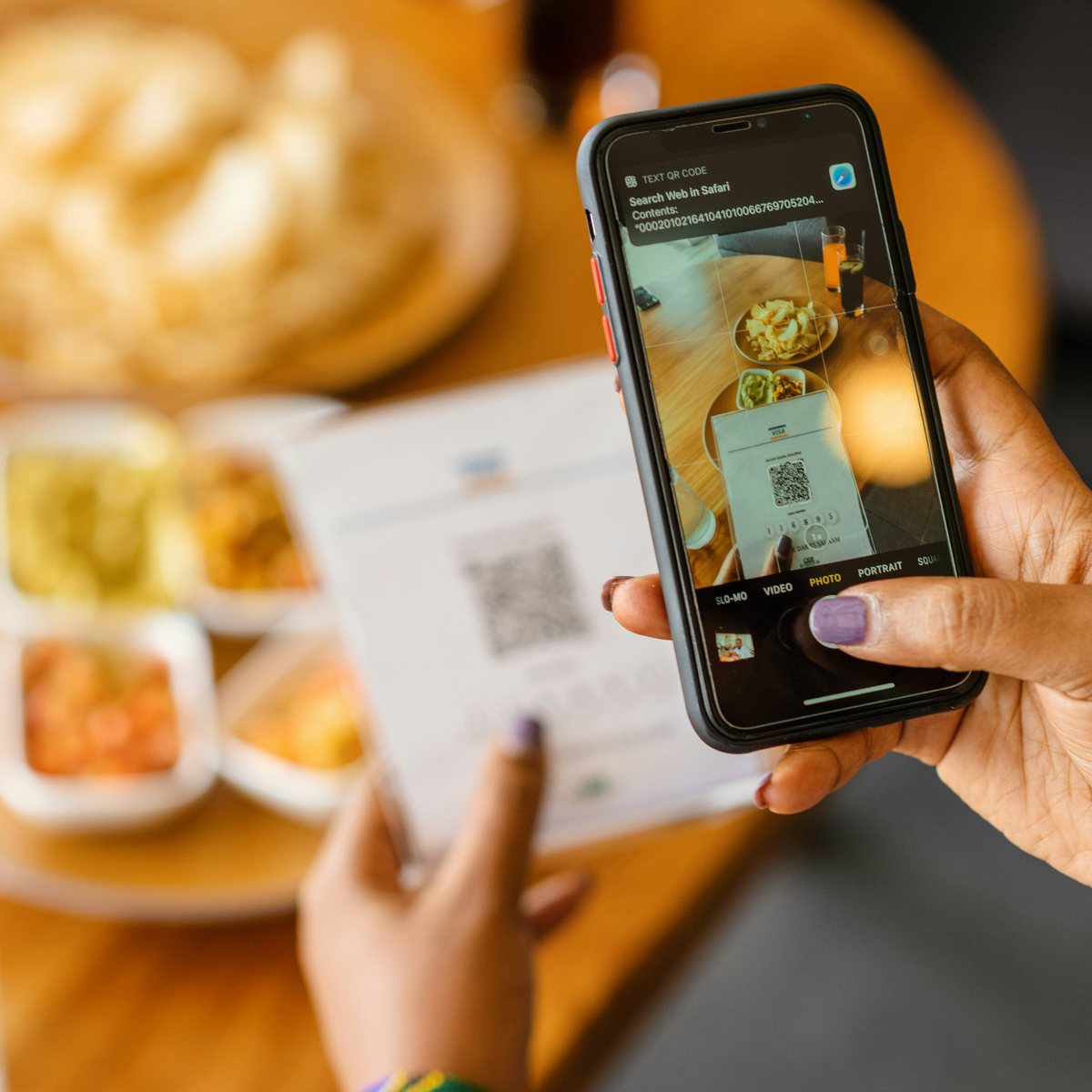 A guest scanning the table QR code with their phone camera to open the menu